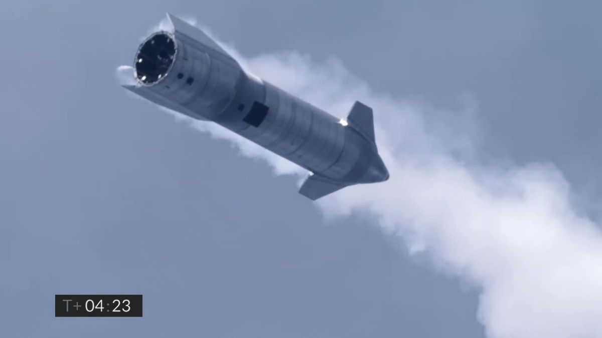 starship spacecraft in mid-air with the pointy side facing towards the ground. smoke is in behind